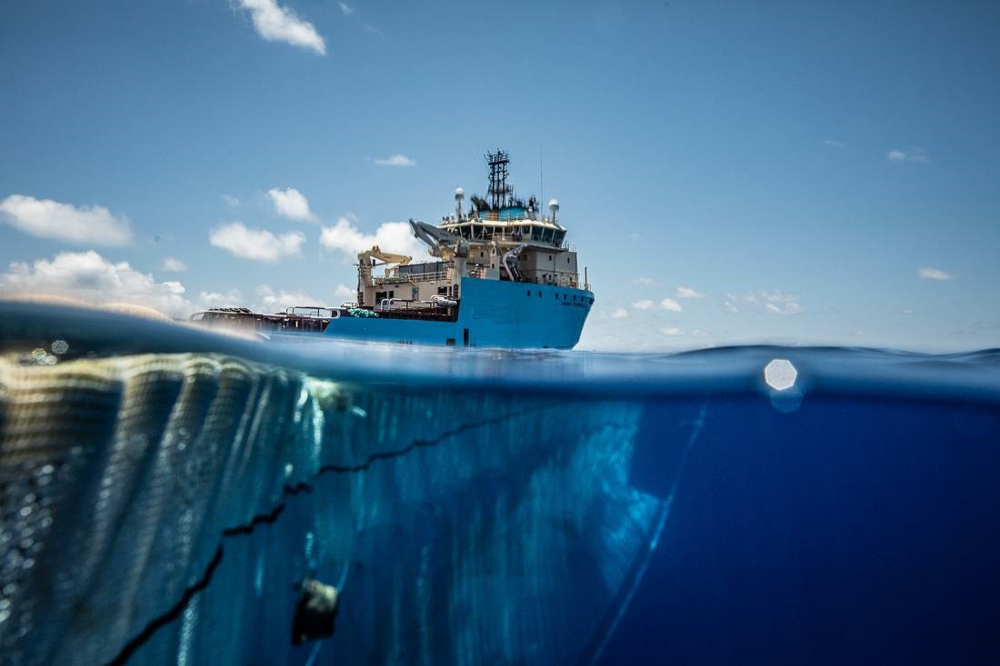 embarcación utilizando redes para recoger residuos plásticos en el océano