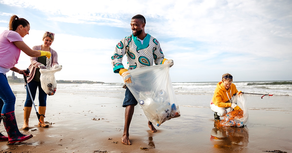 personas voluntarias limpiando playas de residuos plásticos